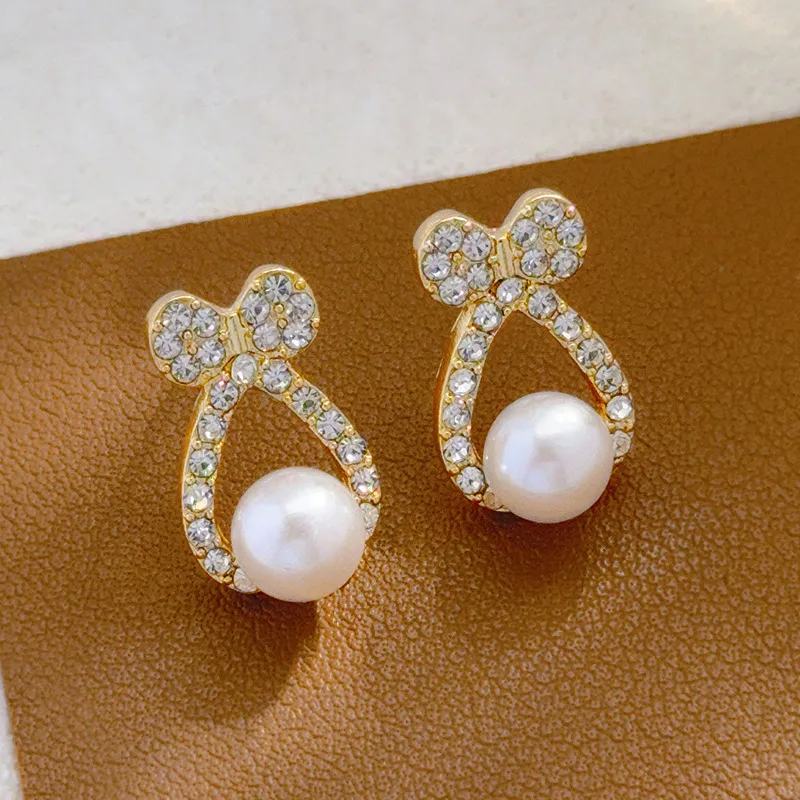 Vergoldete Edelstahl-Ohrstecker mit Schleife & Perle – Elegante Zirkonia-Ohrringe